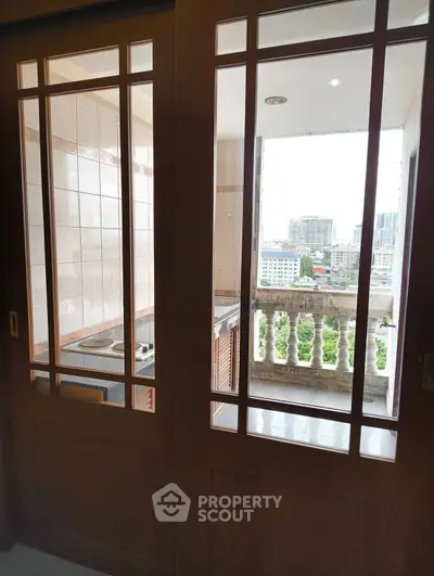 Spacious balcony with city view and elegant wooden sliding doors in a modern apartment.
