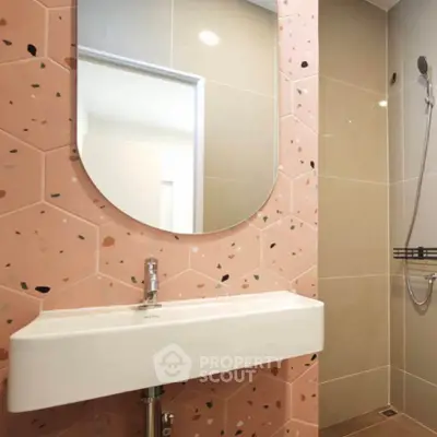 Modern bathroom with stylish pink hexagonal tiles and sleek fixtures.