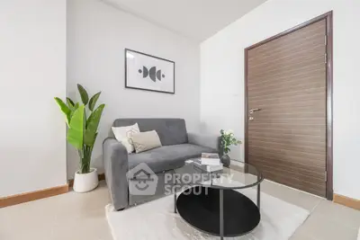 Modern living room with stylish gray sofa, elegant decor, and sleek wooden door.