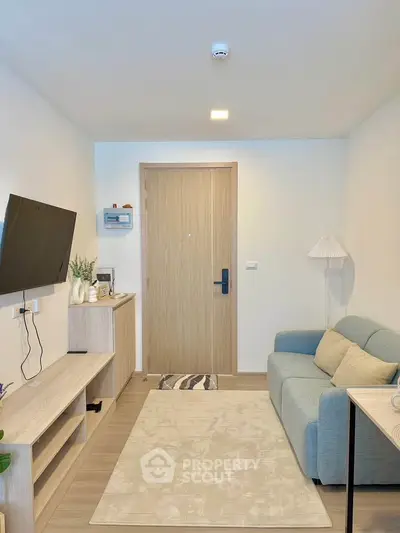 Modern living room with cozy sofa, wall-mounted TV, and stylish decor in a contemporary apartment.