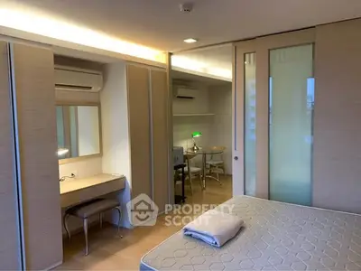 Modern bedroom with built-in wardrobe and study area, featuring sleek design and ample natural light.