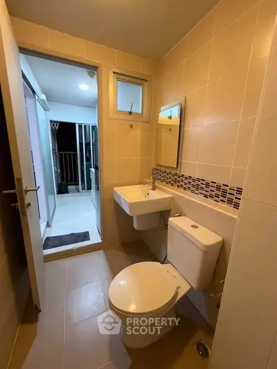 Modern bathroom with sleek fixtures and neutral tiles in a contemporary apartment.