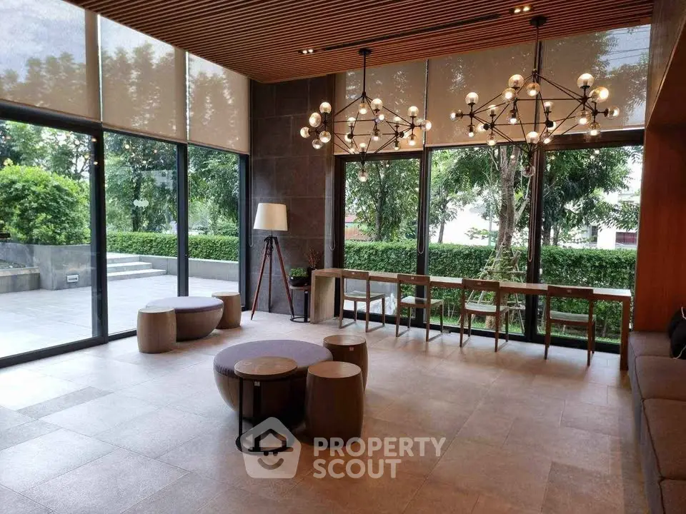 Modern living room with stylish lighting and large windows overlooking greenery.