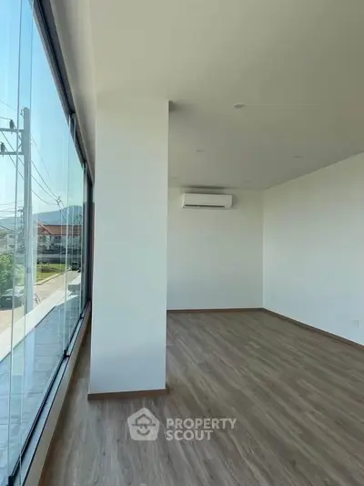 Spacious corner unit with large windows and modern flooring, offering ample natural light and scenic views.