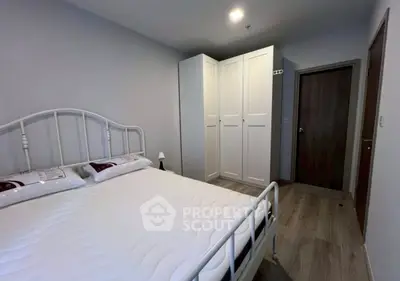 Spacious bedroom with modern white wardrobe and cozy bed setup.