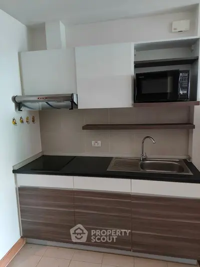 Modern kitchen with sleek cabinetry and built-in microwave, perfect for contemporary living.