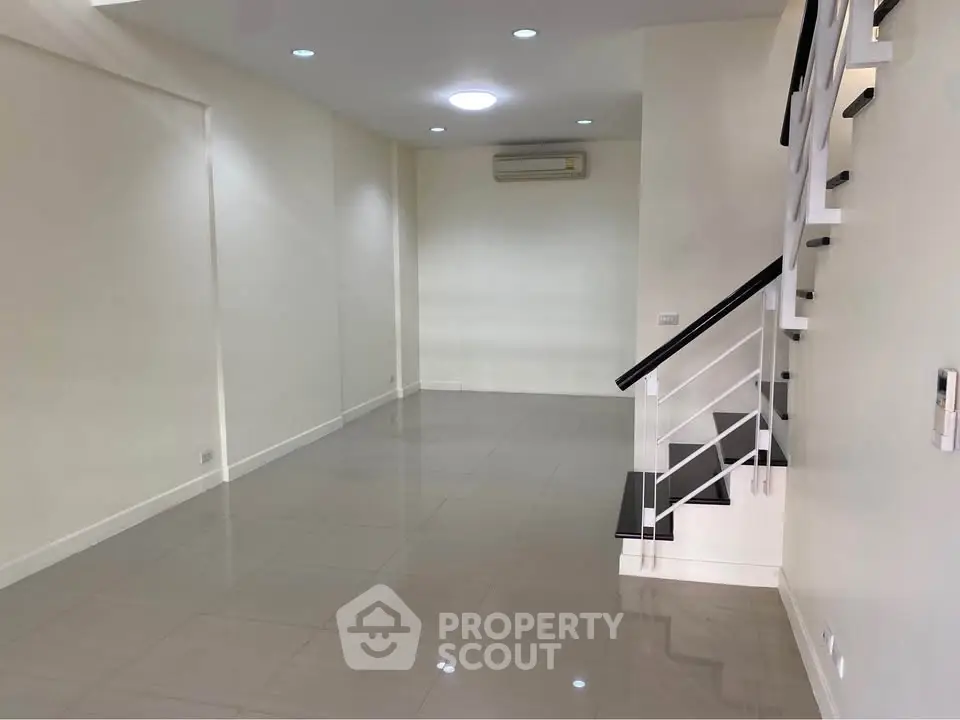 Spacious modern living room with sleek staircase and air conditioning