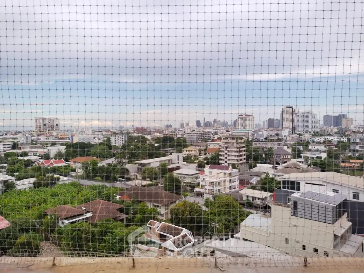 Stunning cityscape view from high-rise balcony overlooking urban skyline and residential area.