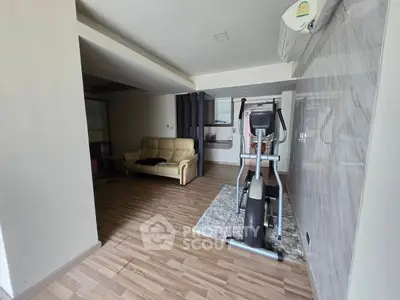 Spacious living area with exercise equipment and modern decor