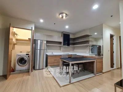 Modern kitchen with sleek appliances and dining area in stylish apartment