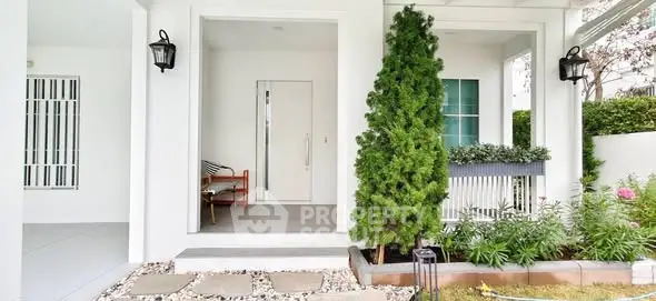 Charming white exterior with lush greenery and inviting entrance, perfect for modern living.