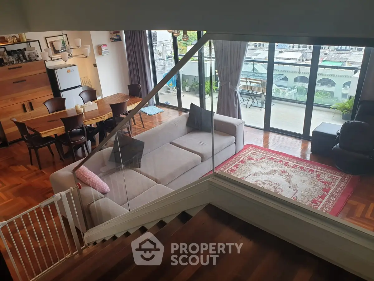 Spacious living room with modern decor and large balcony offering stunning views.