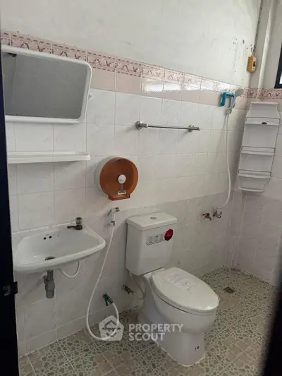 Spacious bathroom with modern fixtures and tiled walls in a real estate property.