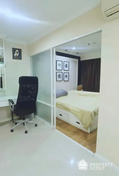 Modern bedroom with sliding glass doors and study area, featuring sleek design and cozy atmosphere.