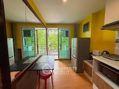 Bright kitchen with open balcony, modern appliances, and vibrant yellow walls.