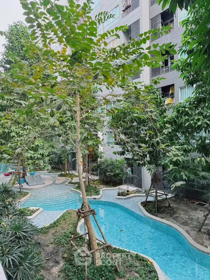 Lush garden view with winding pool in modern residential complex