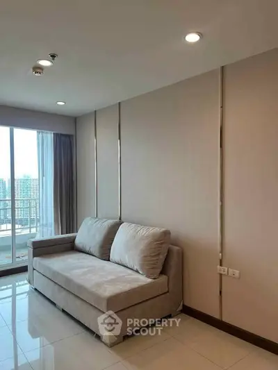 Modern living room with sleek sofa and large windows offering city views