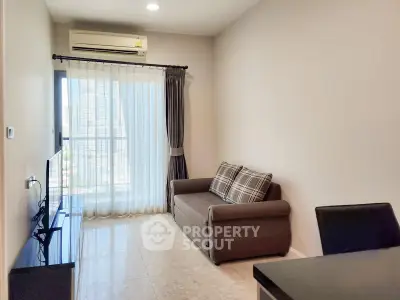 Modern living room with city view, featuring a cozy sofa and sleek TV setup.