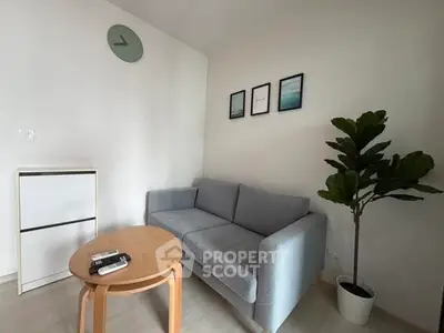 Cozy living room with modern decor, featuring a comfortable sofa, stylish coffee table, and lush indoor plant.