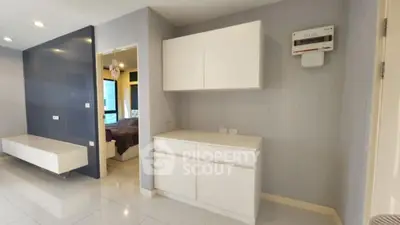 Modern apartment interior with sleek white cabinets and spacious layout.