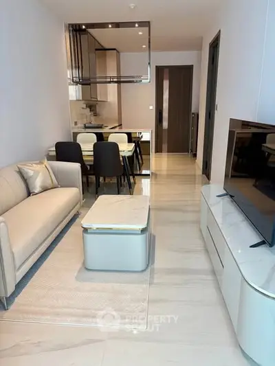 Modern living room with sleek furniture and open kitchen layout in a stylish apartment.