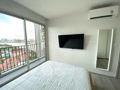 Modern bedroom with balcony view and wall-mounted TV in high-rise apartment.