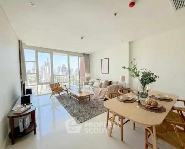 Spacious modern living room with city view, elegant decor, and dining area in a high-rise apartment.