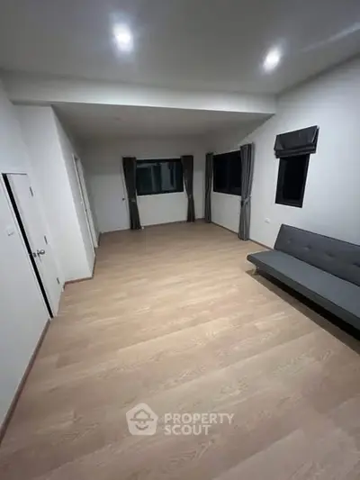 Spacious modern living room with wooden flooring and minimalist decor