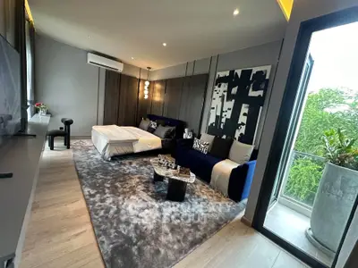 Modern living room with stylish decor and balcony view, featuring cozy seating and elegant design.