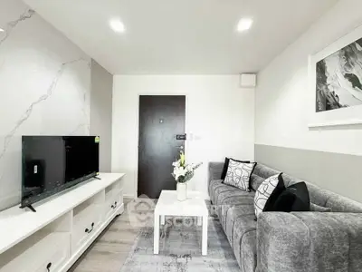Modern living room with stylish decor and sleek furniture, featuring a cozy gray sofa and flat-screen TV.