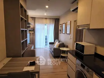 Modern living room with cozy seating and integrated kitchen appliances in a stylish apartment.