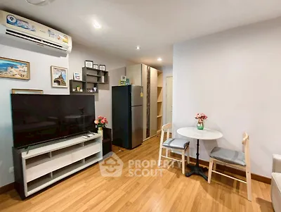 Modern living room with wooden flooring, stylish decor, and a cozy dining area in a contemporary apartment.