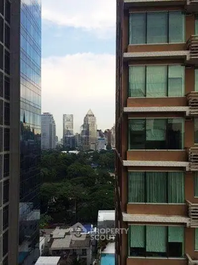 Stunning urban view from high-rise building with lush greenery and city skyline.