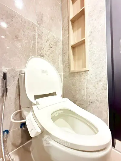 Modern bathroom with sleek marble tiles and high-tech toilet in luxury apartment.