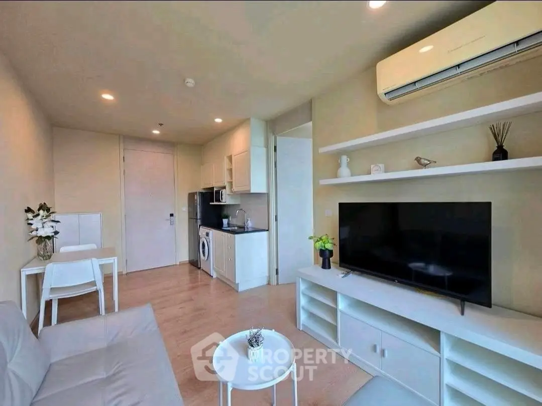 Modern living room with sleek furniture and built-in appliances in a cozy apartment.