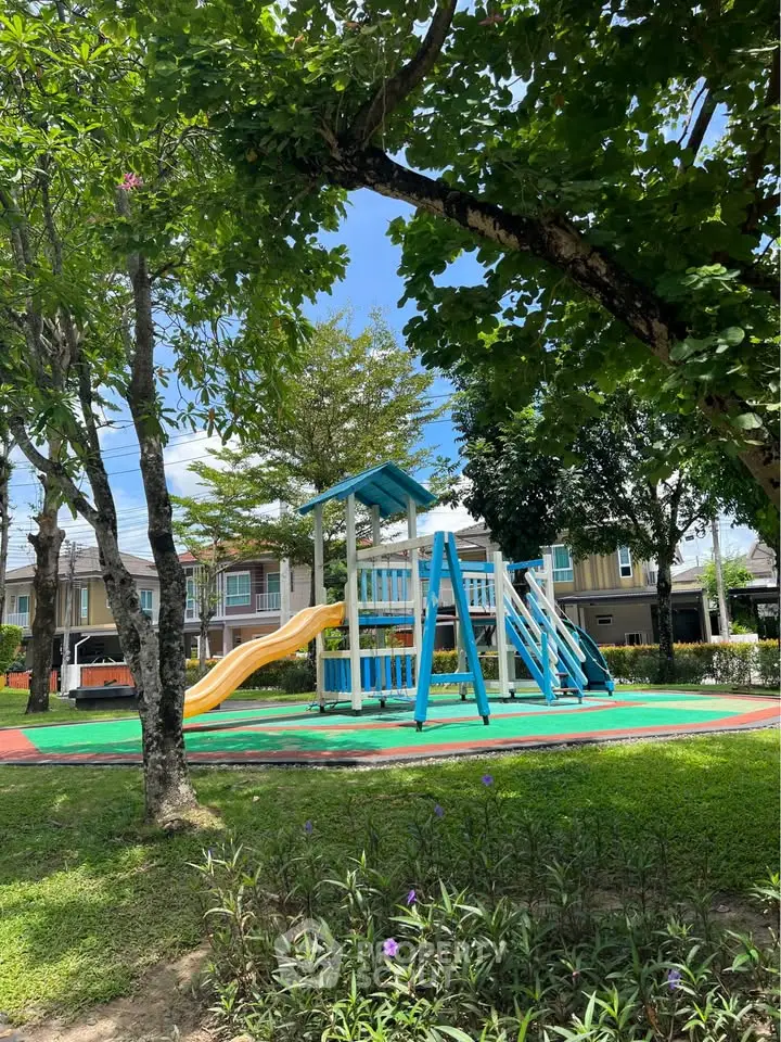 Charming residential playground with colorful slides and lush greenery, perfect for family-friendly living.