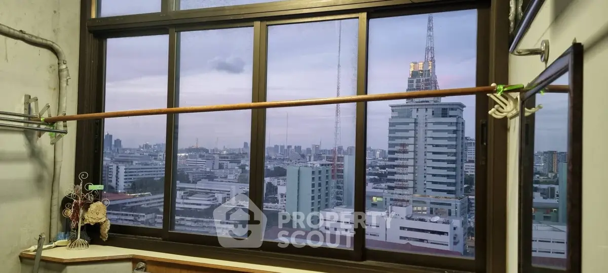 Stunning cityscape view from a high-rise window, showcasing urban skyline at dusk.