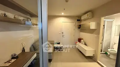 Modern apartment interior with compact living area and bathroom, featuring sleek design and efficient use of space.