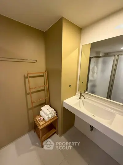 Modern bathroom with sleek sink and towel rack, ideal for contemporary living.