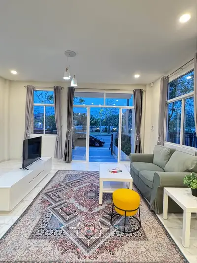 Spacious living room with modern decor and large windows offering a serene view.