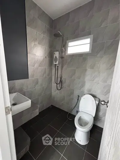 Modern bathroom with sleek tiles and contemporary fixtures in a stylish real estate property.