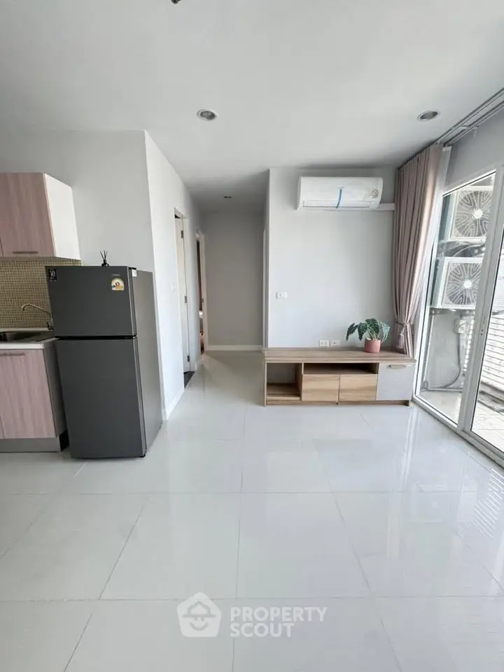 Modern apartment interior with sleek kitchen and spacious living area, featuring natural light and contemporary design.