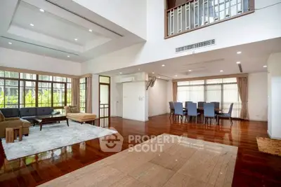 Spacious open-plan living and dining area with hardwood floors and large windows.