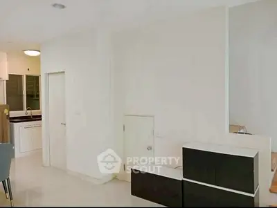 Modern minimalist interior with sleek black and white cabinetry in a spacious living area.