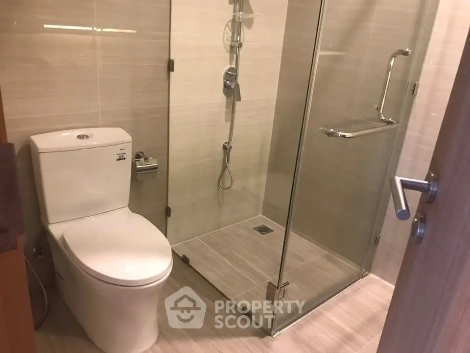 Modern bathroom with glass shower and sleek fixtures in a contemporary apartment.