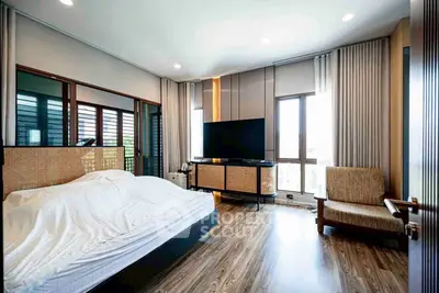 Spacious bedroom with modern decor and large windows for natural light