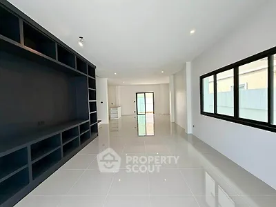 Spacious modern living room with sleek tile flooring and large windows for natural light.