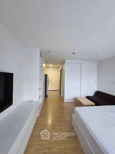 Modern studio apartment with sleek design and ample natural light, featuring a cozy living area and stylish furnishings.