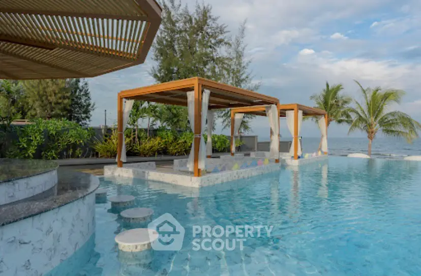 Luxurious beachfront pool with cabanas and stunning ocean view