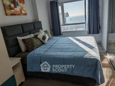 Spacious bedroom with ocean view and modern decor in high-rise apartment.